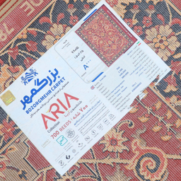 فرش ماشینی 700 شانه بزرگمهر مدل بلوچی کد 78015 زمینه قرمز حاشیه لاکی